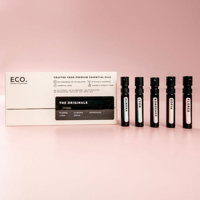 Set of 'ECO. Modern Essentials' mini perfume bottles with packaging on a pink background.