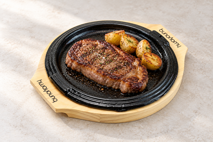 Round Iron Sizzling Steak Plate with Wood Base, 9.25". Serving suggestion.