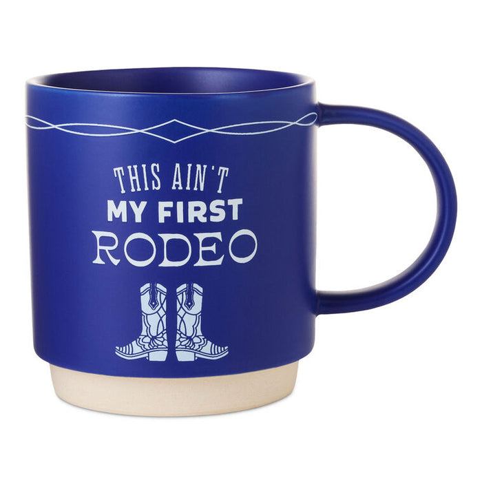 Cobalt blue ceramic mug with white text that reads “This ain't my first rodeo” and a cowboy boots design, stackable base.
