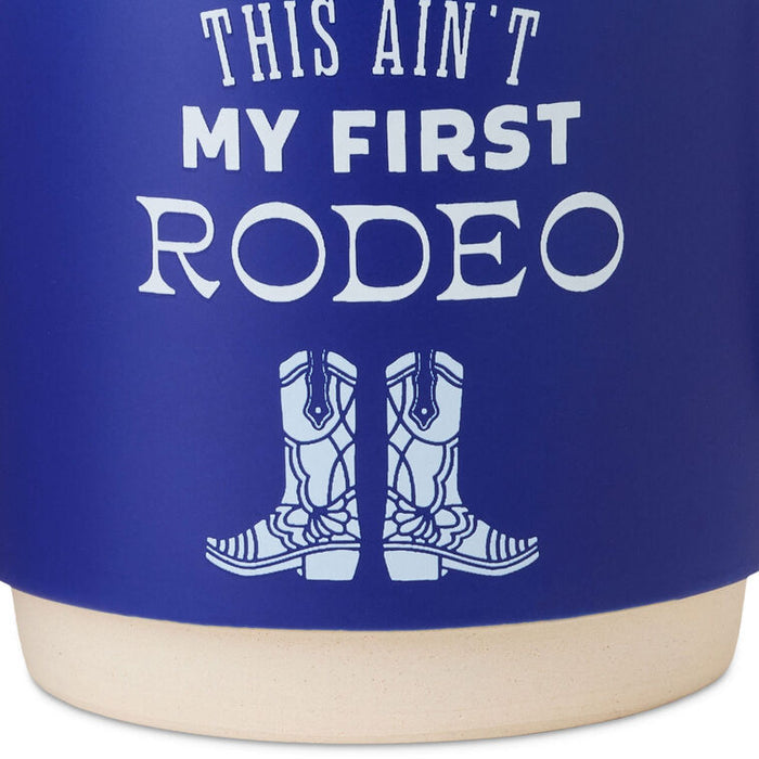 Cobalt blue ceramic mug with white text that reads “This ain't my first rodeo” and a cowboy boots design, stackable base.